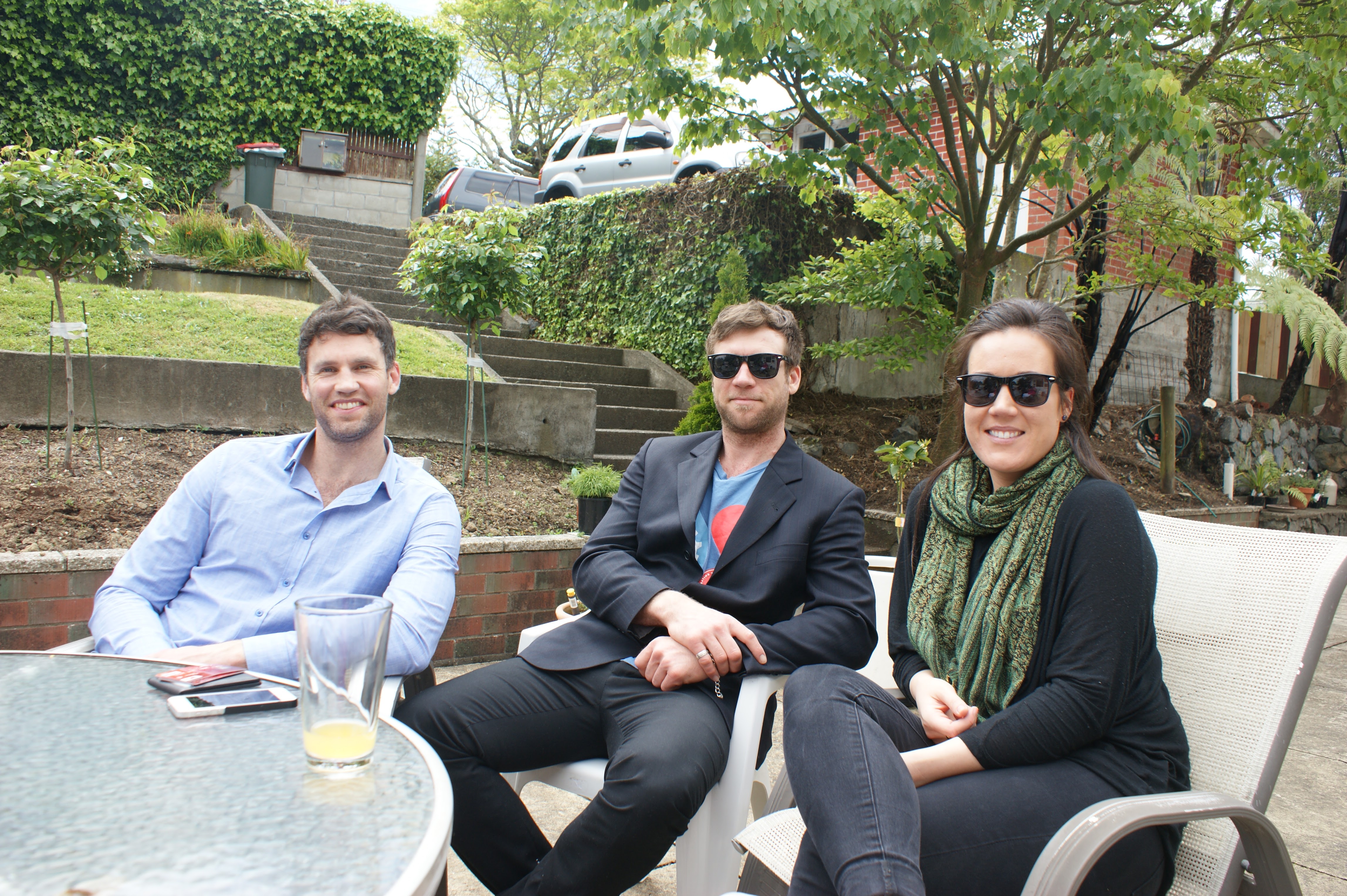 Group of young adults sitting round smiling.